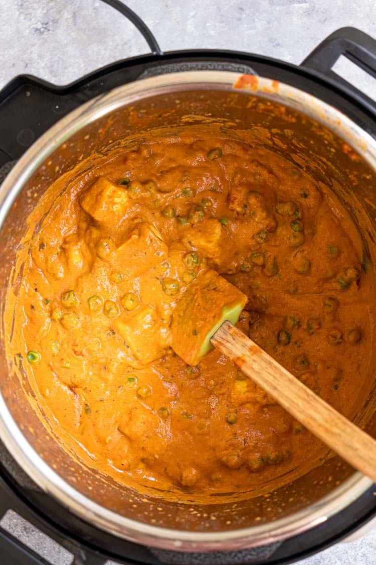 peas and paneer curry in an instant pot with a spatula