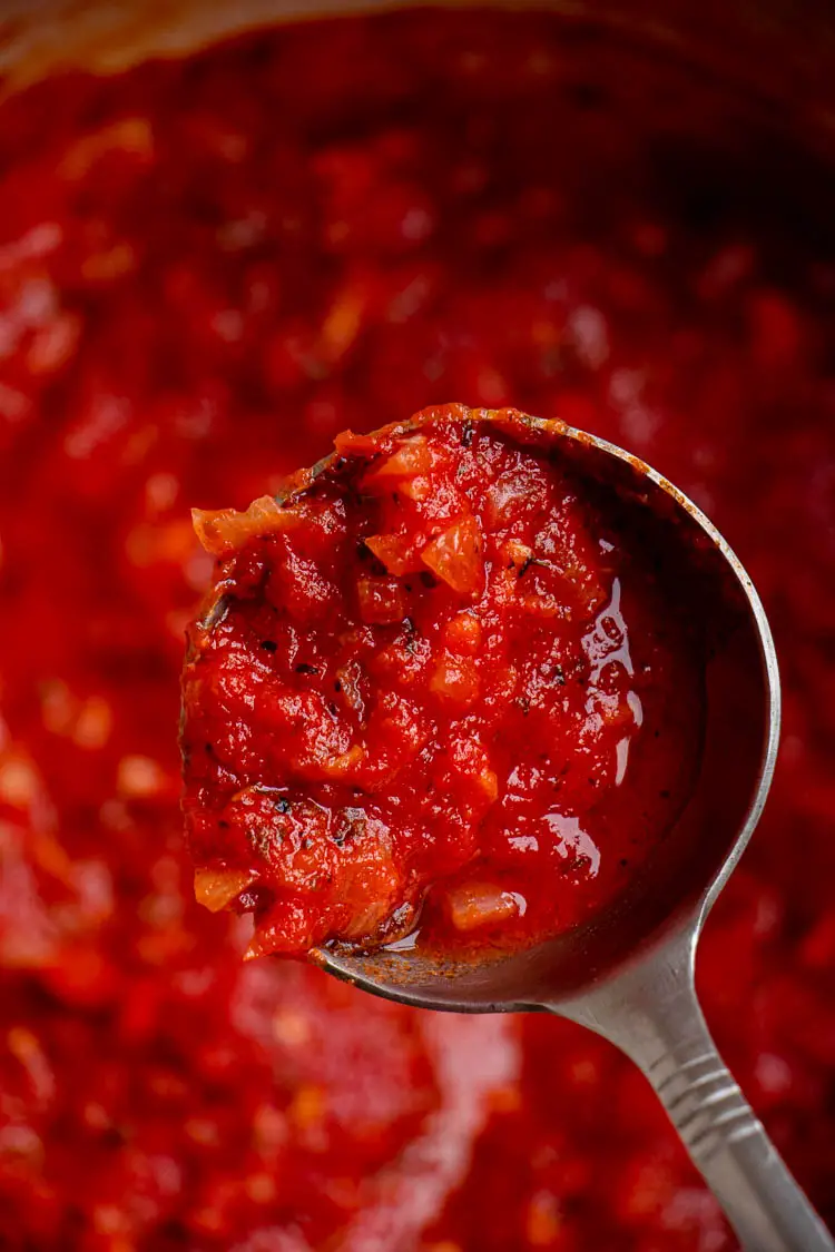 homemadde pizza sauce in a ladle, texture of pizza sauce