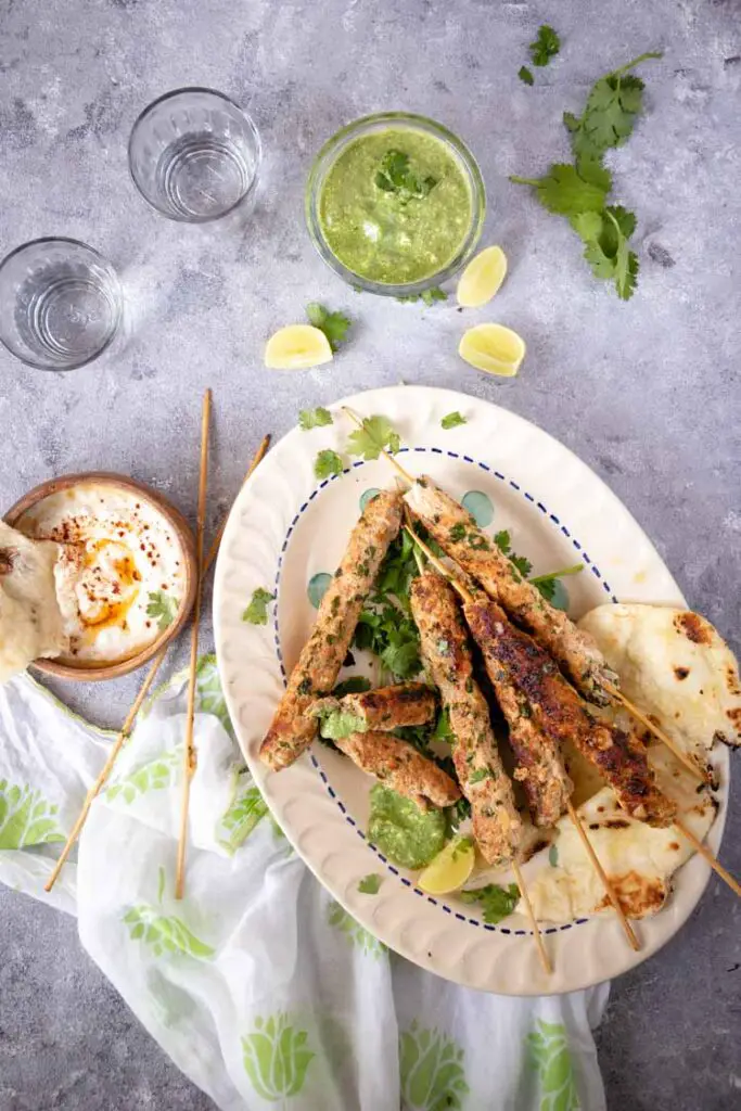 Seekh kebab with mint chutney and tzatziki sauce. chicken seekh kebab, Seekh kebab up close food pbotography, chicken seekh kebab