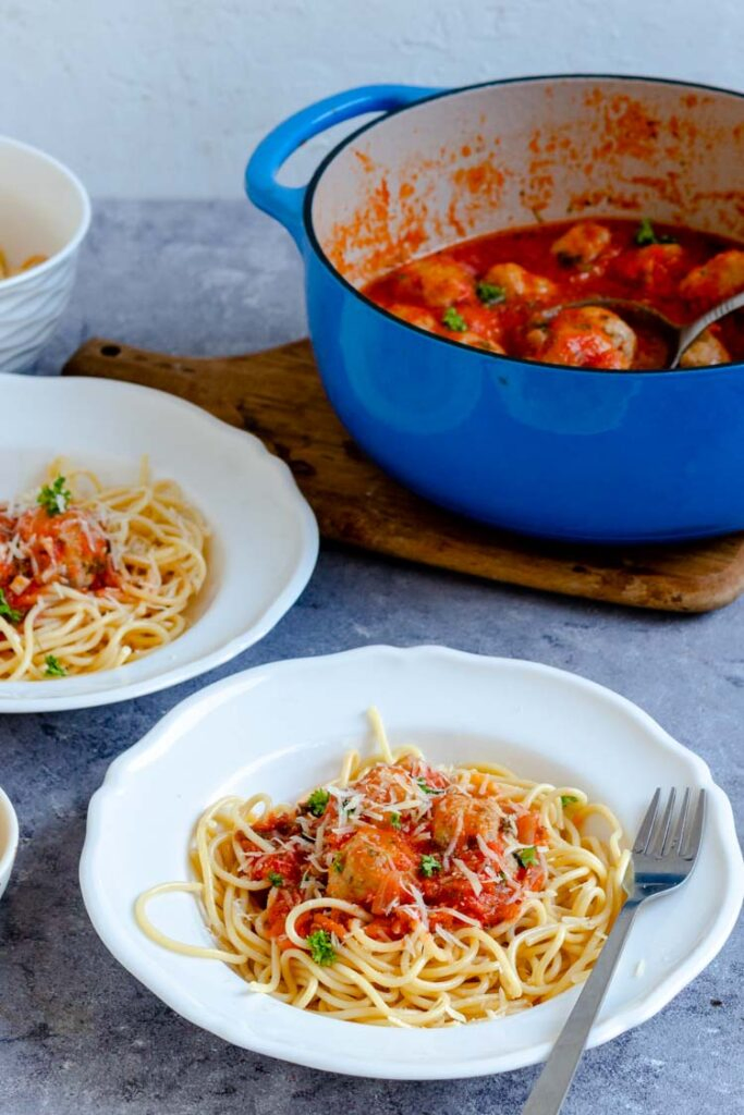 spaghetti sauce with chicken meatballs served over spaghetti in pasta bowls