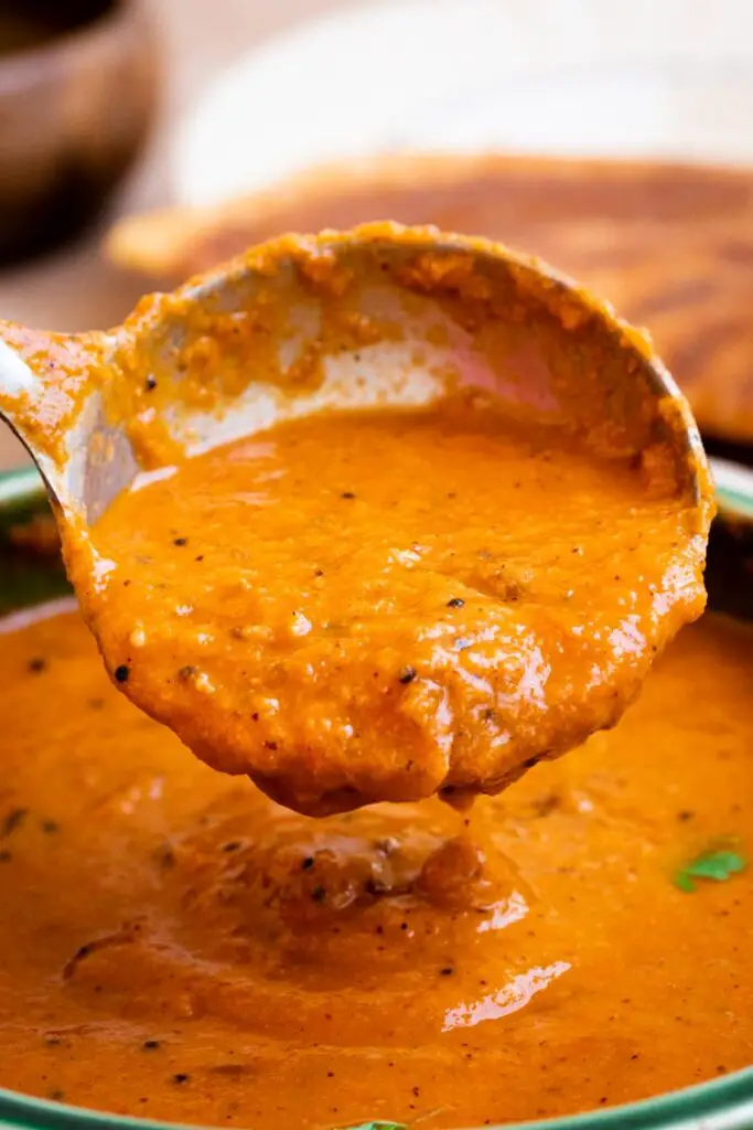 thakkali kuzhambu in a ladle