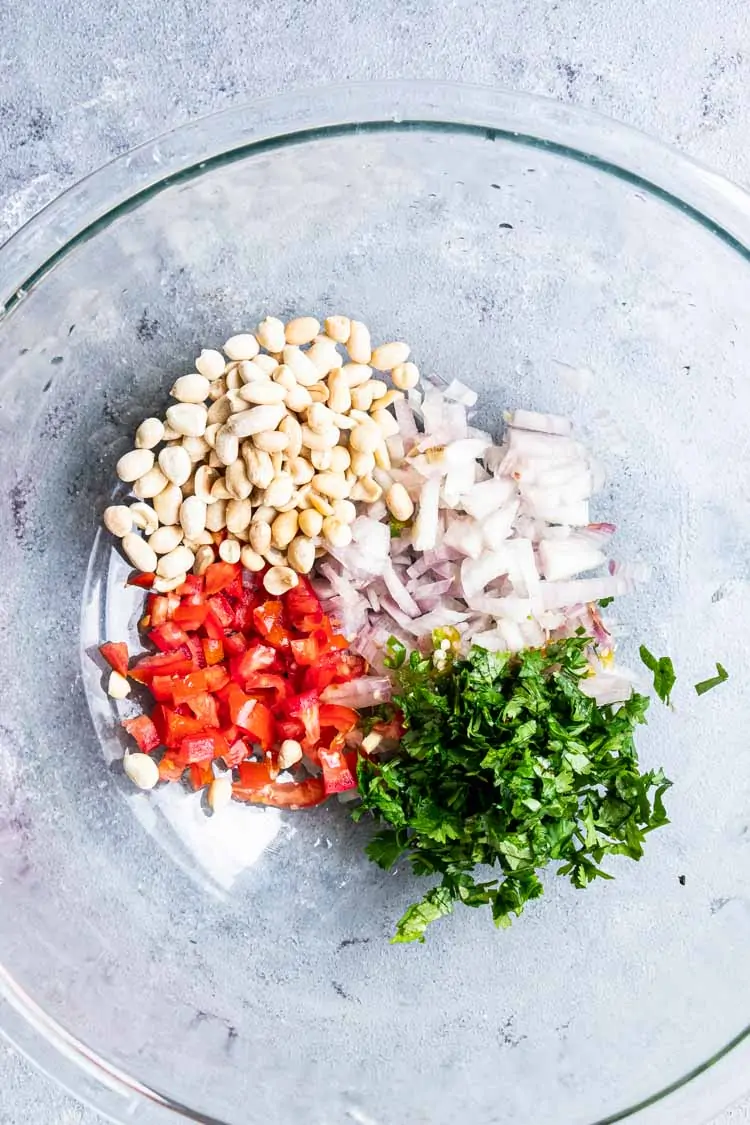 chopped onions, tomatoes, peanuts and cilantro leaves in a mixing bowl