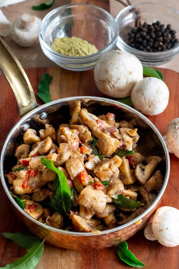 chopped mushrooms stir fried with onions, tomatoes and curry leaves, served in a pan